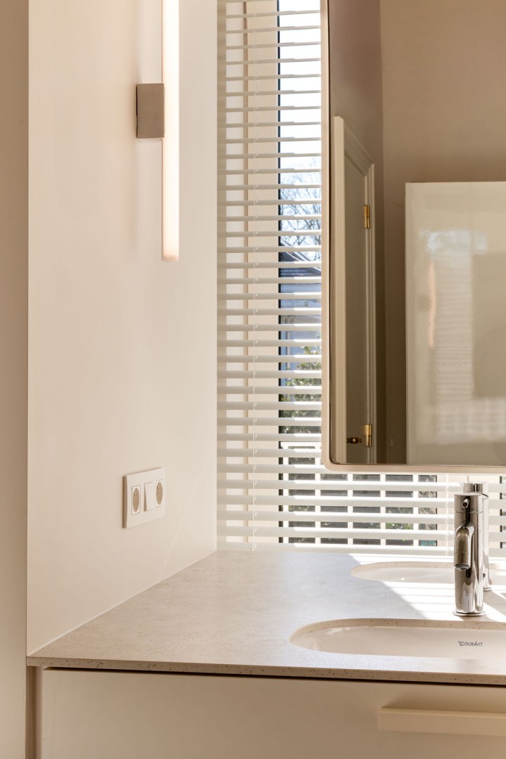 detail lavabo met spiegel en zicht op raam